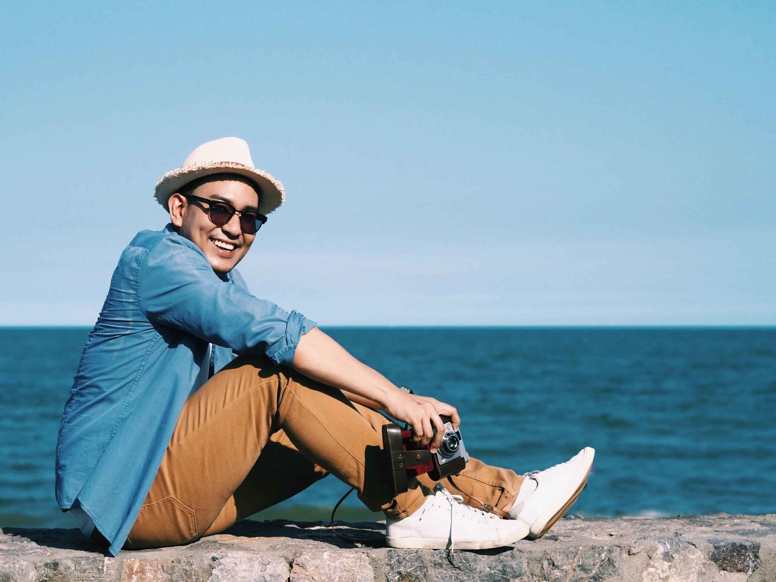  Happy young traveler man sitting beach